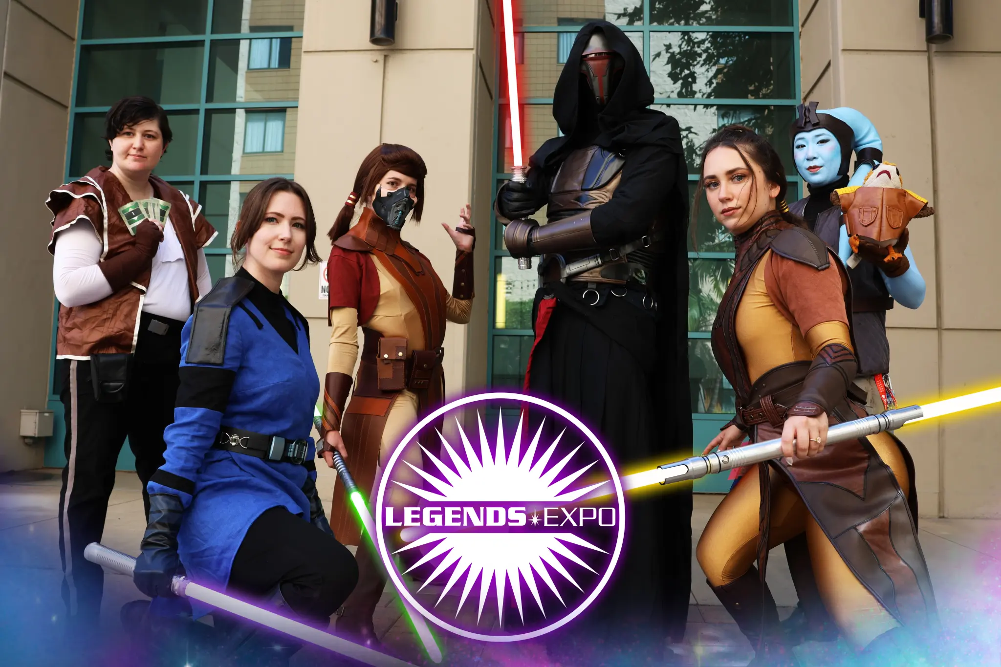Cosplayers dressed as Knights of the Old Republic characters Bastila Shan, Mission Vao, and a Czerka Corporation employee play pazaak with fans.