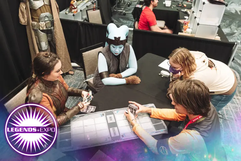 Cosplayers dressed as Atton Rand, a Jedi Knight, Bastila Shan, Darth Revan, Mission Vao, and a plush porg in a Carth Onasi costume stand behind the Legends Expo logo.