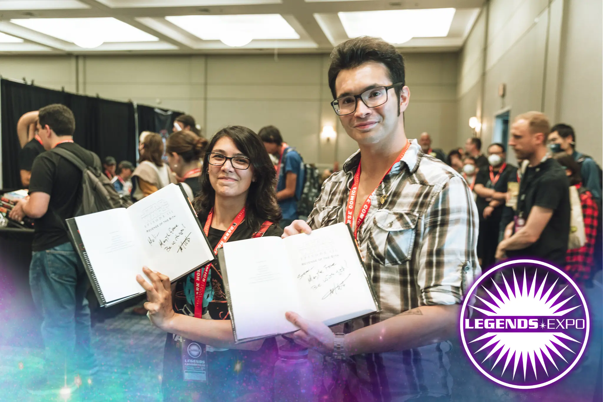 Two con goers holding freshly signed books